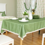 đĩa trắng trên khăn trải bàn màu xanh lá cây