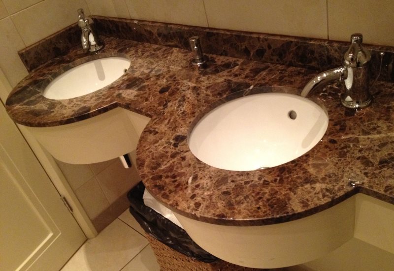 Plan de travail en granit dans la salle de bain avec deux lavabos