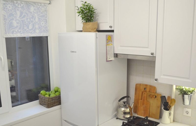 Hvitt kjøleskap nær kjøkkenvinduet