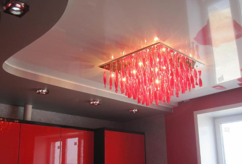 Red lamp on the stretch ceiling of the kitchen