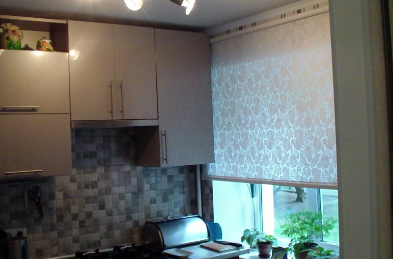 Ljus rullgardin på fönstret i ett litet kök