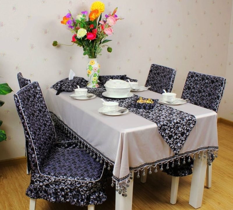 A beautiful tablecloth with a fringe to match the covers on the chairs