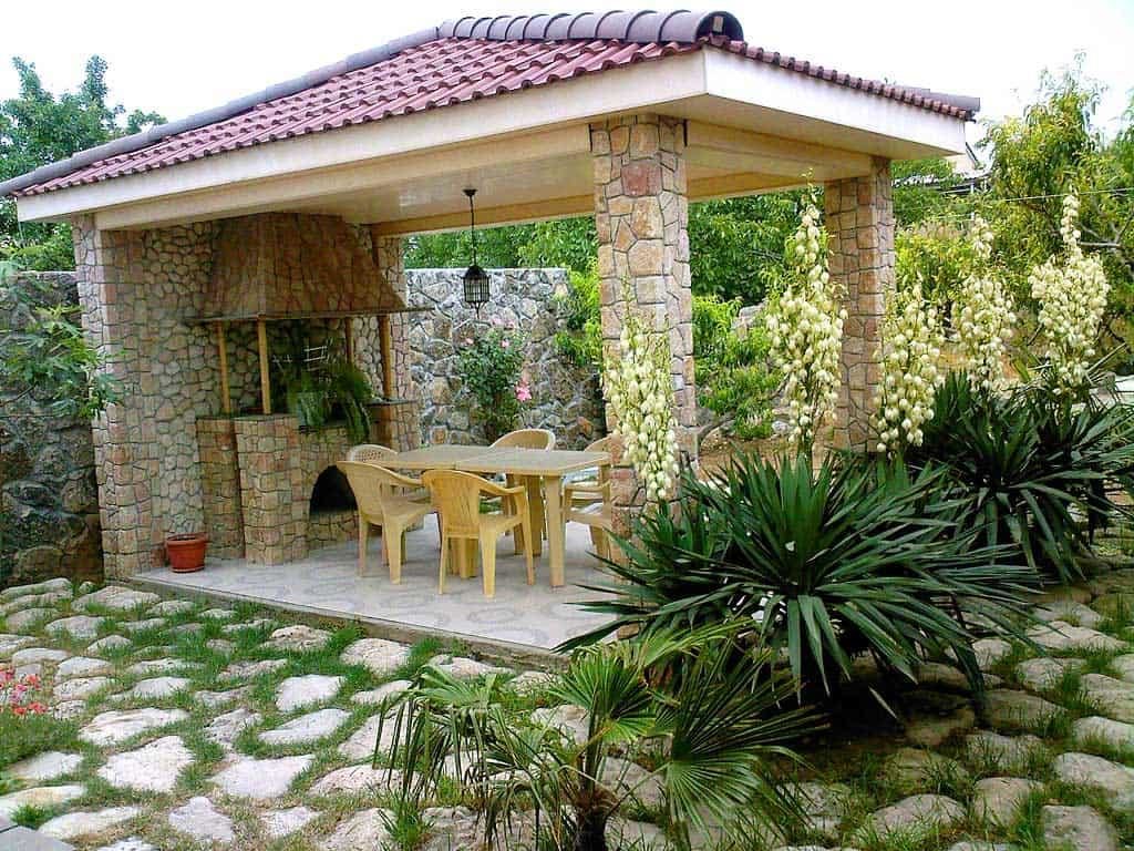 Stone pillars of a summer kitchen with a metal roof