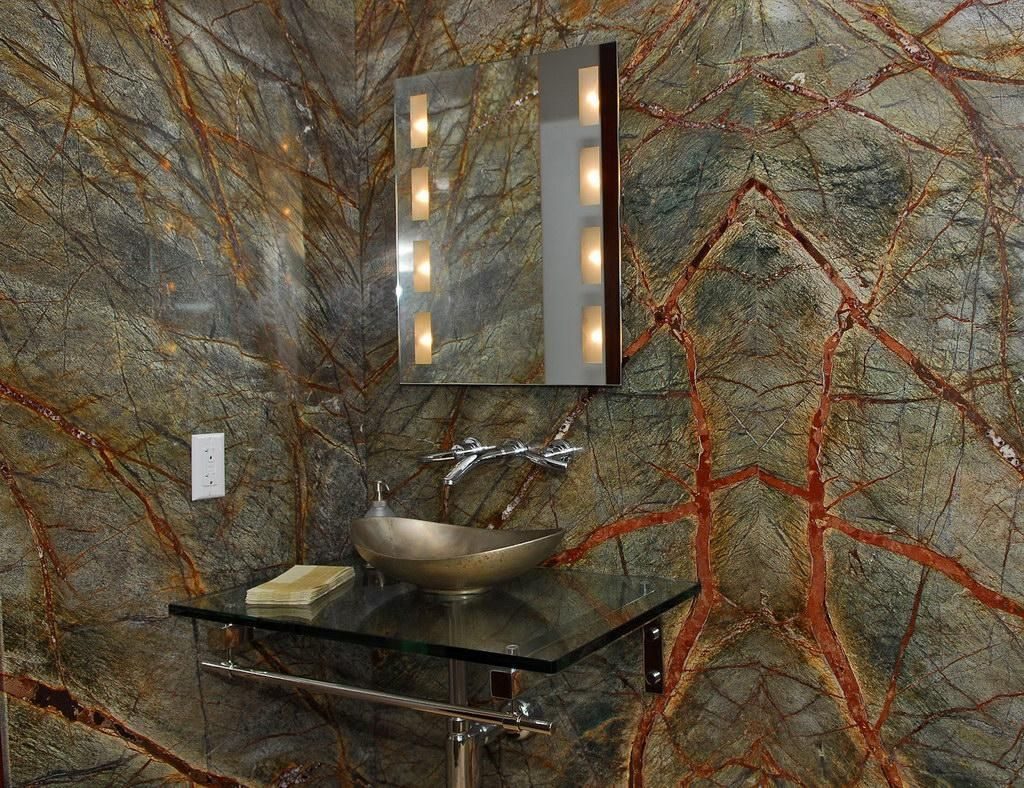 Dzelzs rūdas plankumi marmora flīzēs uz vannas istabas sienas