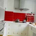 Tablier rouge dans la cuisine avec un ensemble blanc