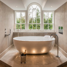 White bathtub in front of a window in a country house