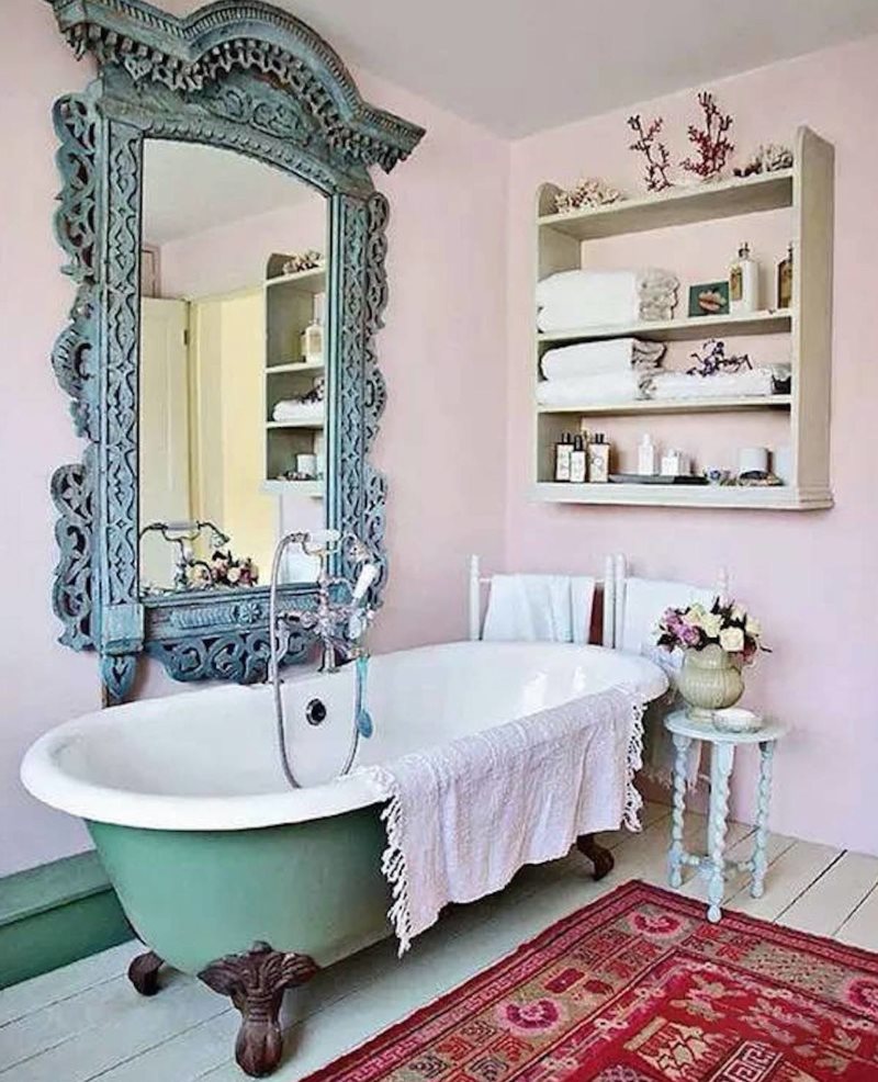 حمام القدم المصنوع من الحديد الزهر أسفل مرآة مع إطار منحوت