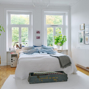 غرفة نوم بيضاء مع سرير بجانب النافذة