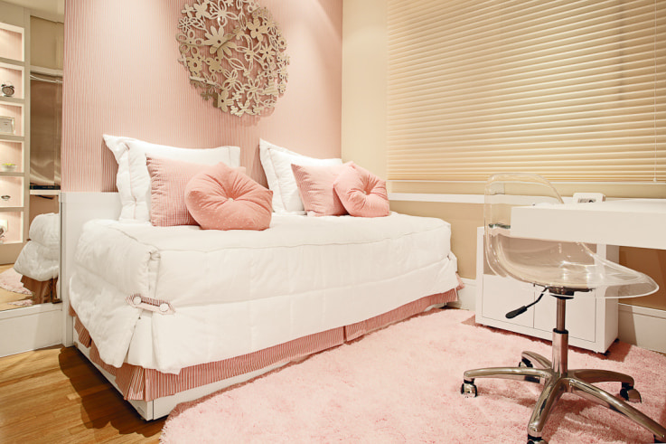 Rožinės pagalvės ant baltos lovos