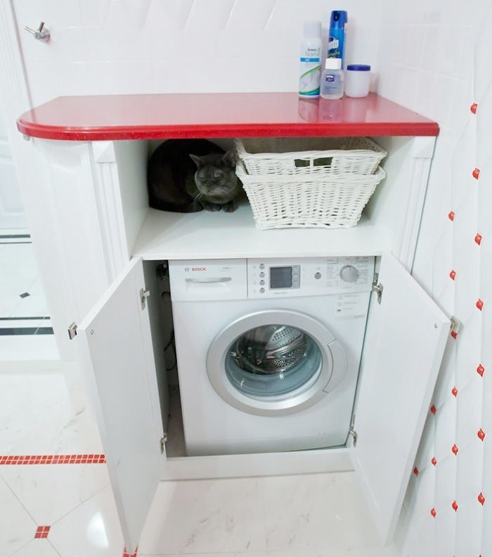 מדף אדום מעל מכונת הכביסה בחדר האמבטיה