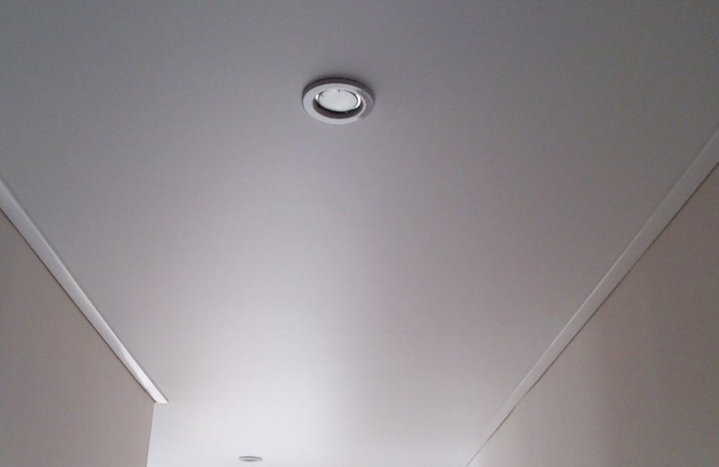 Luminaria empotrada en la superficie plana del techo del pasillo.