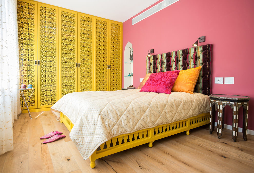Keltainen sänky vaaleanpunaisessa huoneessa