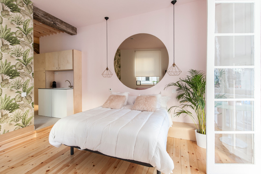 Biela posteľná prikrývka v ružovej stene spálne