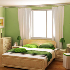 غرفة نوم خضراء مع سرير بجانب النافذة