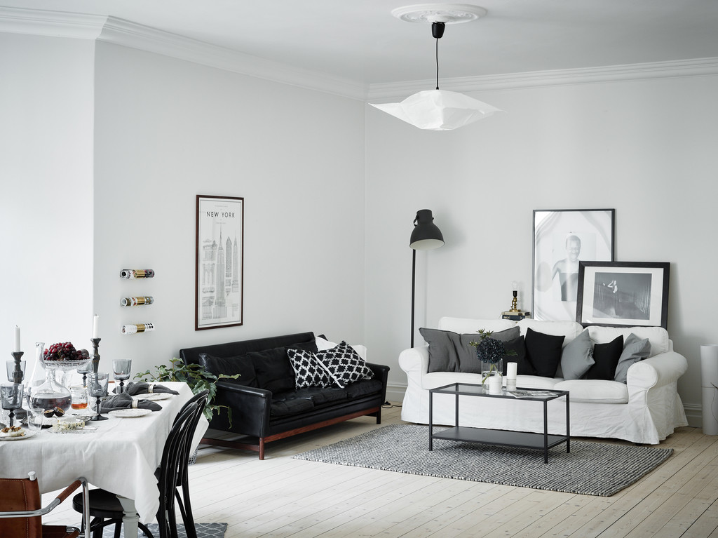 أريكة سوداء في غرفة معيشة على الطراز الاسكندنافي