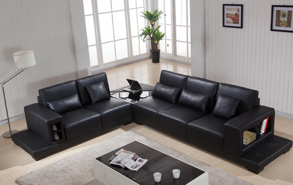 Μαύρος γωνιακός καναπές στο πολυστρωματικό πάτωμα της αίθουσας
