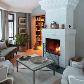 Salon confortable avec une cheminée en brique blanche