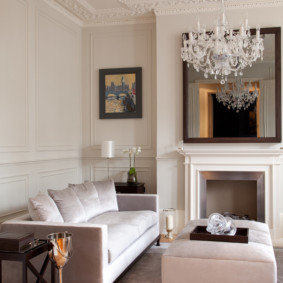 White chandelier on the ceiling of the room with fireplace