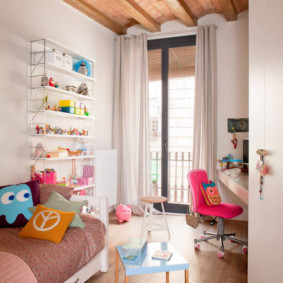 غرفة الأطفال الصغيرة مع باب إلى الشرفة