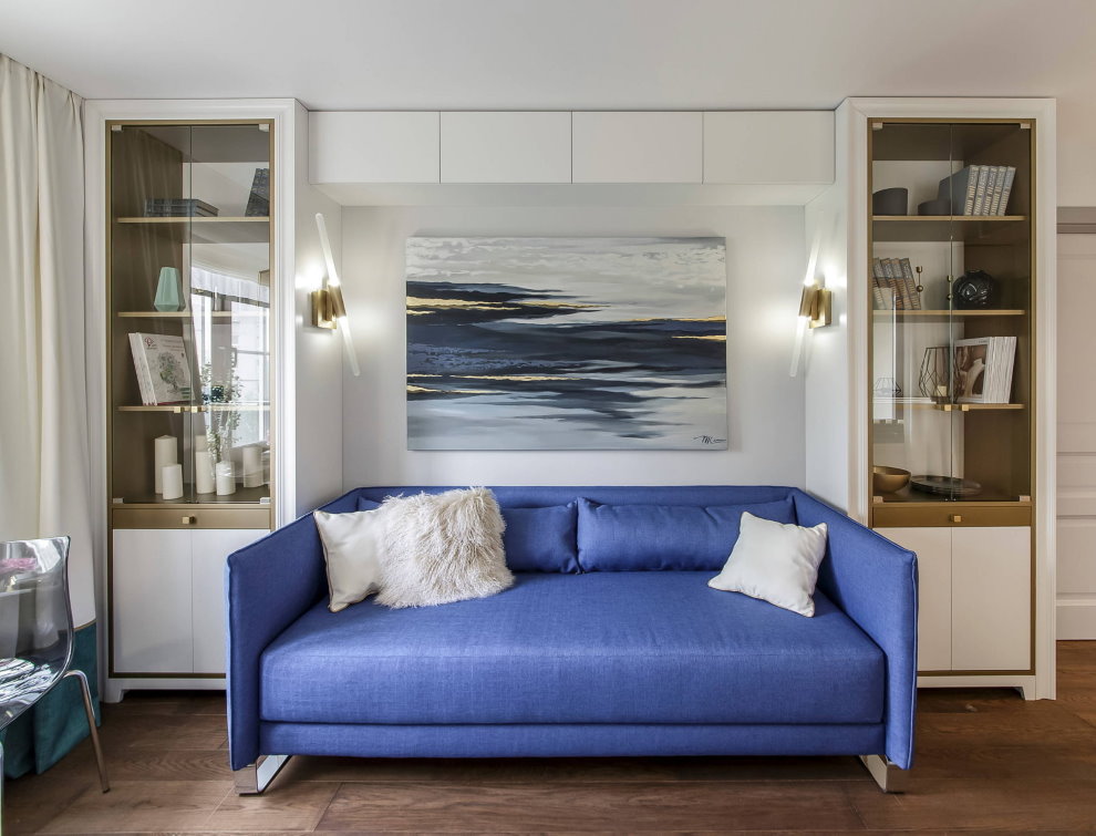 أريكة زرقاء في غرفة المعيشة في شقة استوديو