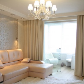 La suddivisione in zone del soggiorno con tende beige