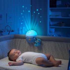 طفل صغير في سرير مع إضاءة ليلية على الجانب