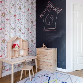 Children's chest of drawers in front of a slate wall