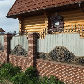 Gard din cărămidă în fața unei case din lemn