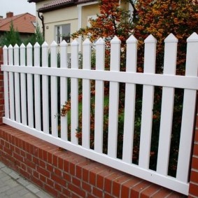 Gard cu stâlpi de cărămidă în grădina din față a unei case particulare