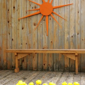 Simple bench in front of a wooden fence