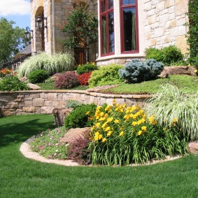 Compact flower bed in front of a brick house