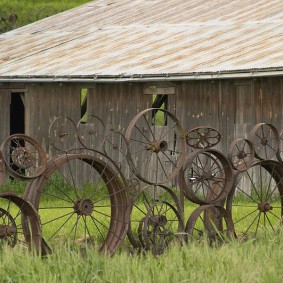 Kerítés az országban a régi fém kerekekből