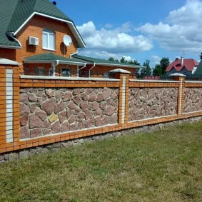 Stone and brick fence on a strip foundation