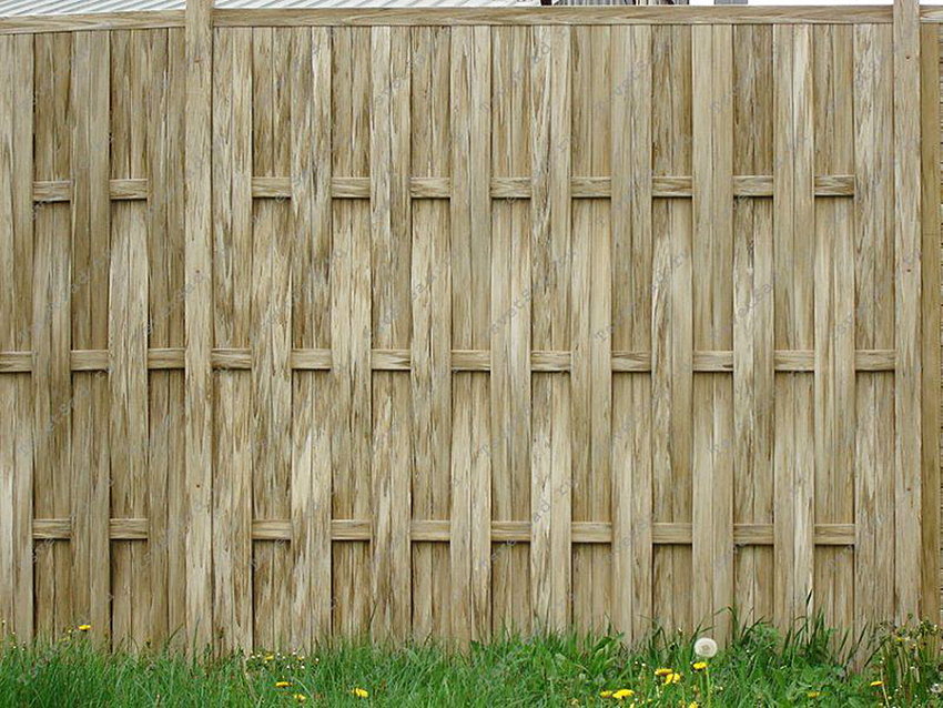 Clôture en plastique gris-brun sous la clôture en bois