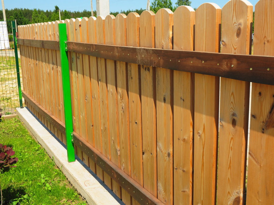 Wooden fence on green poles