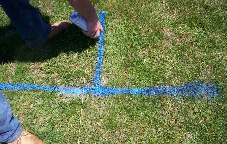 Marquage à la peinture bleue des lieux d'installation des poteaux de clôture