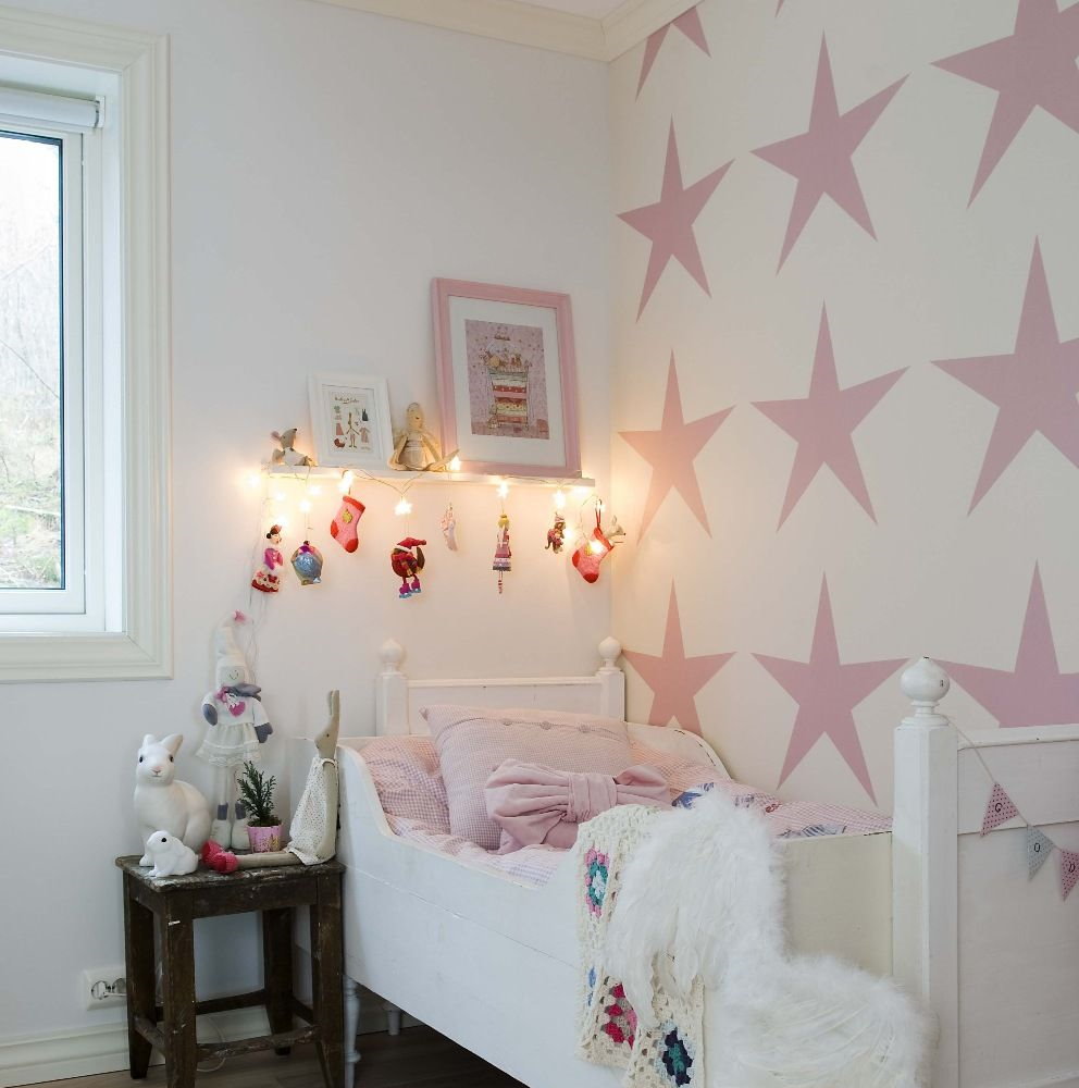 Rozā zvaigznes uz tapetes meitenes guļamistabā