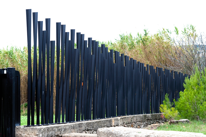 Sculptural fence on the border of a summer cottage