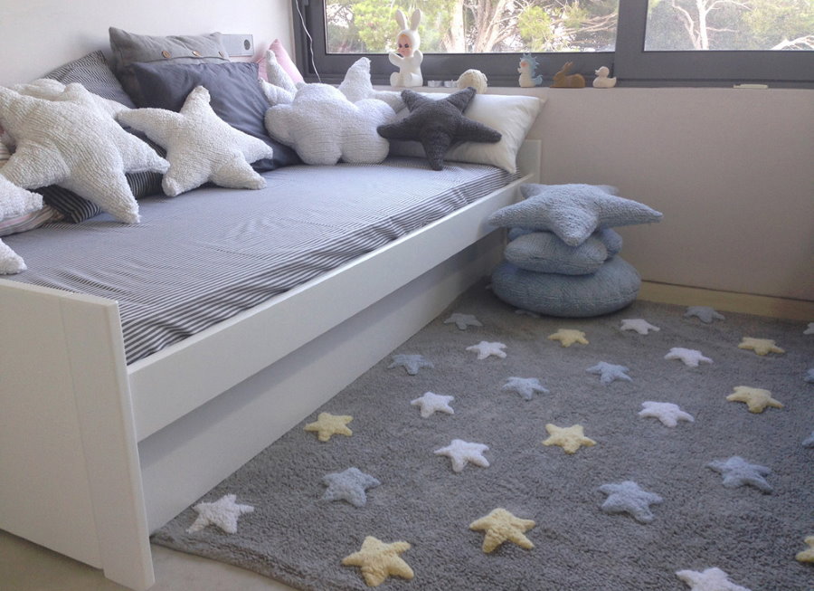 سجادة رمادية مع نجوم أمام السرير