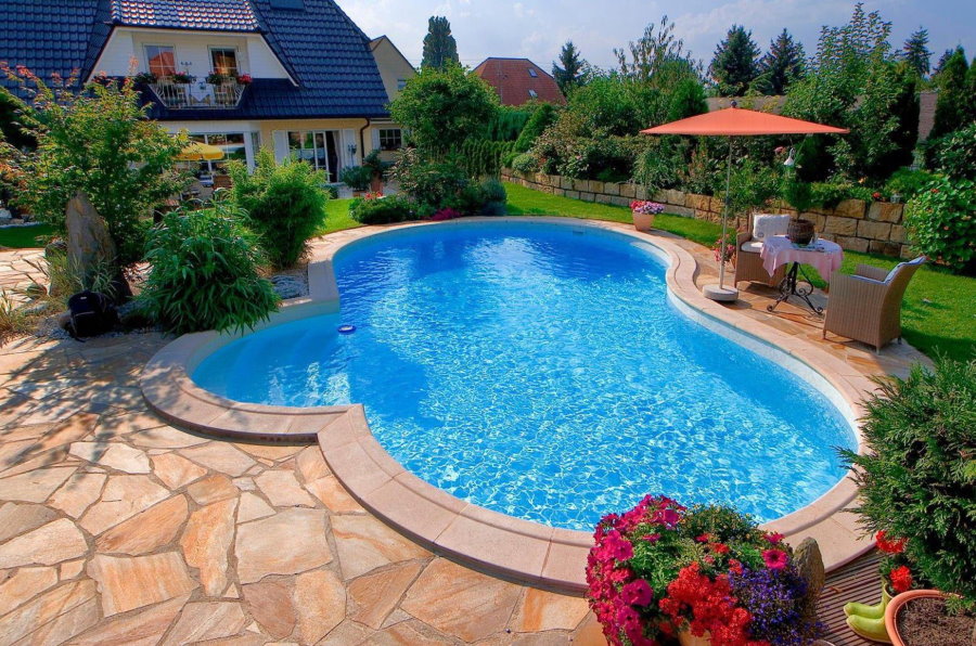 Plateforme en pierre devant une piscine aux eaux bleues