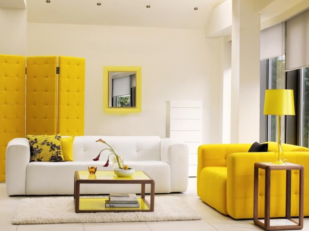 Schermo giallo dietro un divano bianco