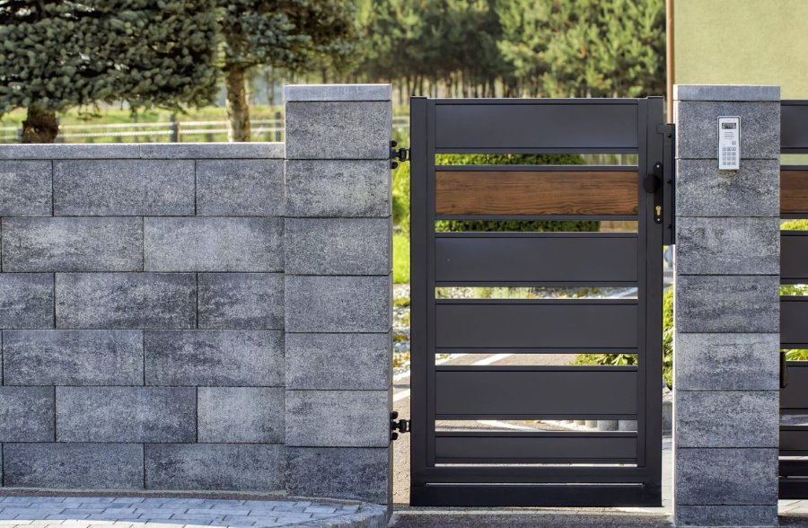 Portão de metal em cerca de bloco tipo concreto