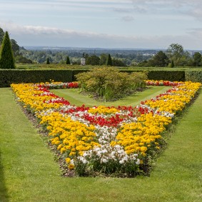Lyse blomsterbed i en hage i engelsk stil