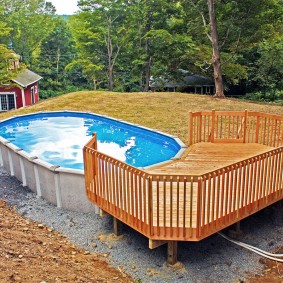 Piattaforma di legno di fronte alla piscina a telaio