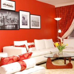 Balta sofa prie raudonos sienos
