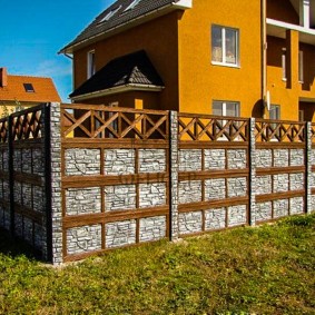 Gard înalt în fața unei case cu două etaje