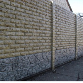 Pietra artificiale sulla superficie di una recinzione in cemento