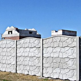 Long fence made of monolithic concrete sections