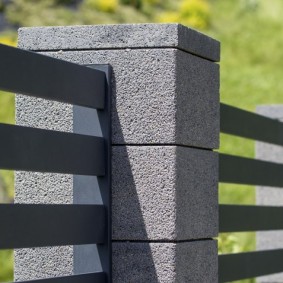 Закрепване на метални секции на оградата към стълбове от блокове