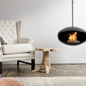 Hanging bio fireplace next to a soft chair